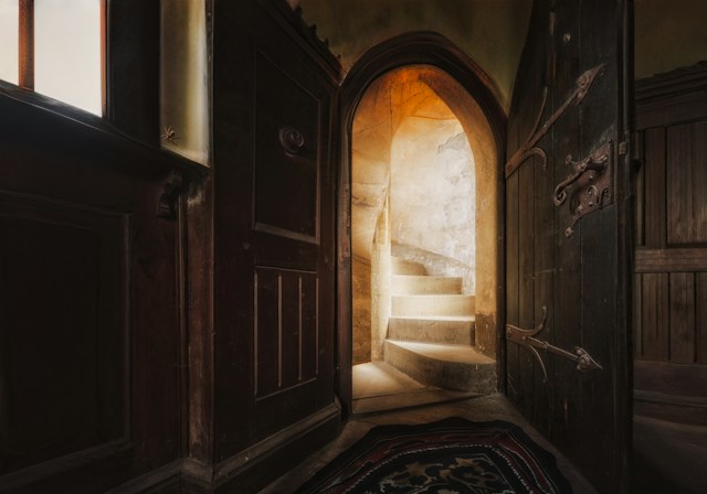 A beam of sunlight revealing a pathway through open doors