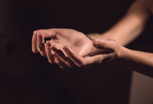 Open hands holding a gift of light in a community gathering