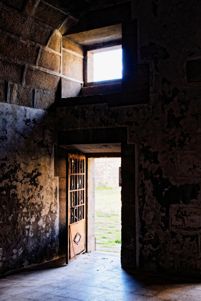 An open doorway with warm light streaming through into a room