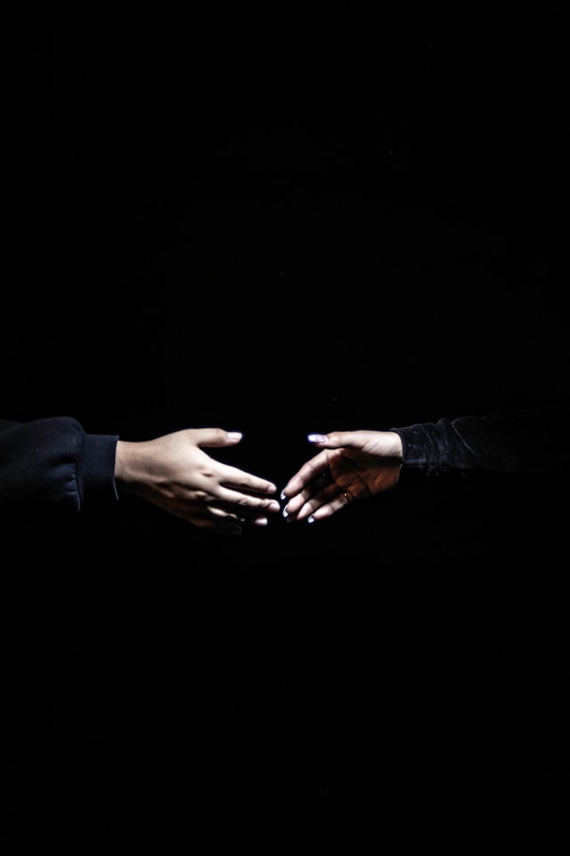 Two hands—one open, one hesitant—reaching toward each other - representing grace meeting fear or confrontation meeting restoration.